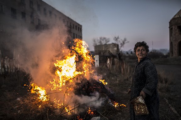 Karine, 57, launches a fire in between two buildings after winter. (Yulia Grigoryants)